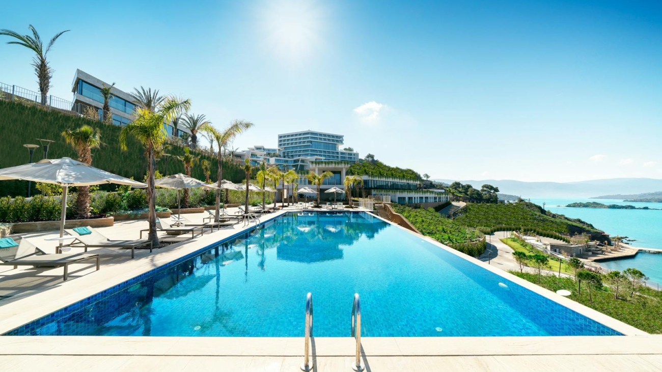 A luxurious seaside resort in Bodrum, Turkey, featuring a stunning infinity pool under sunny skies.