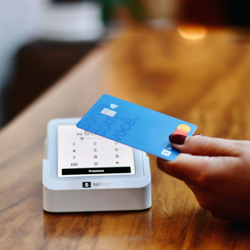 a person holding a credit card in front of a machine