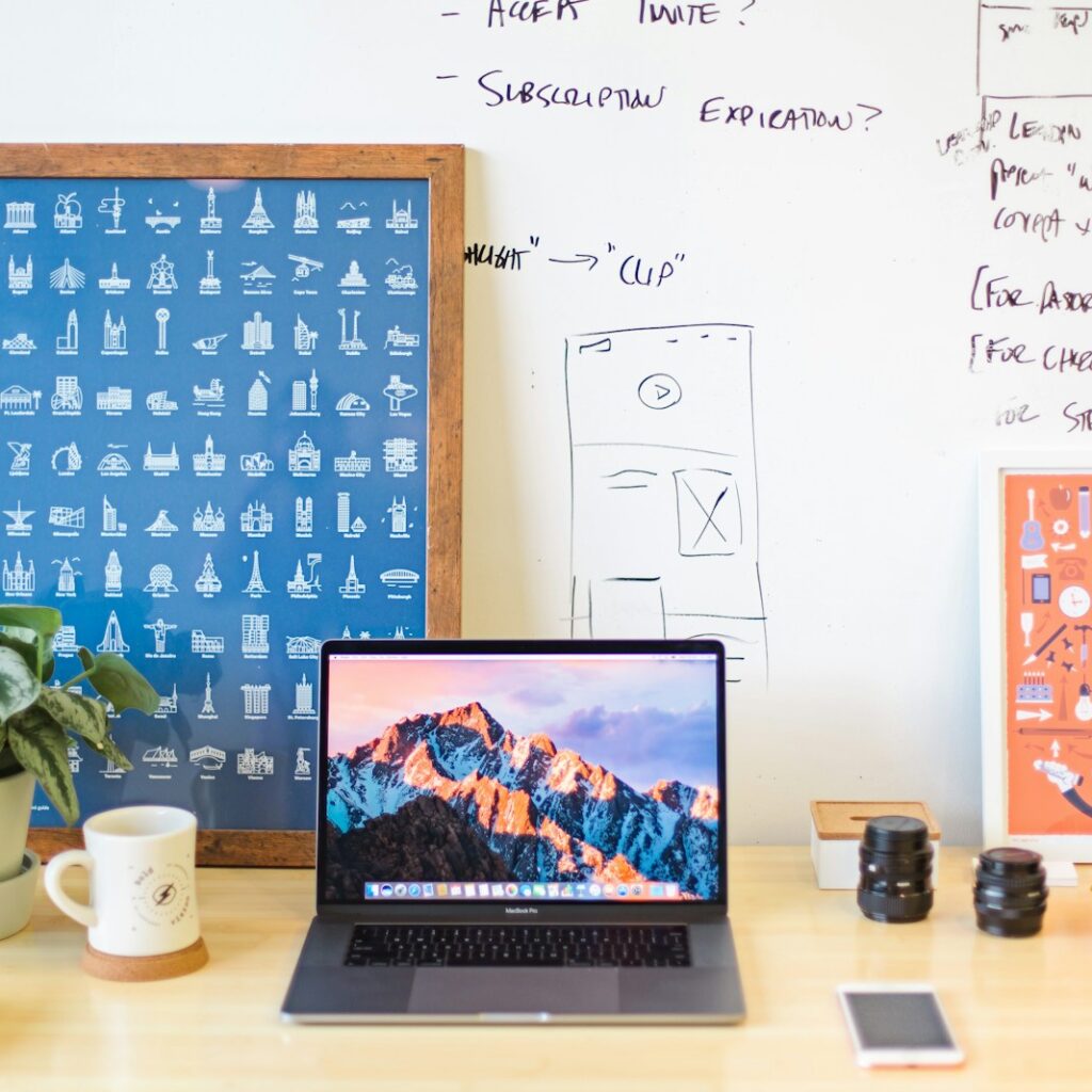 MacBook Pro on brown wooden table beside white mug