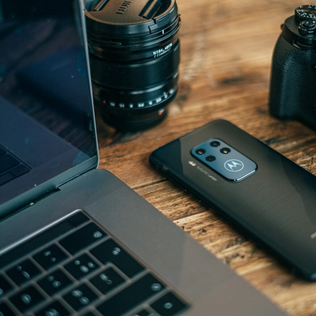 black smartphone beside MacBook Pro