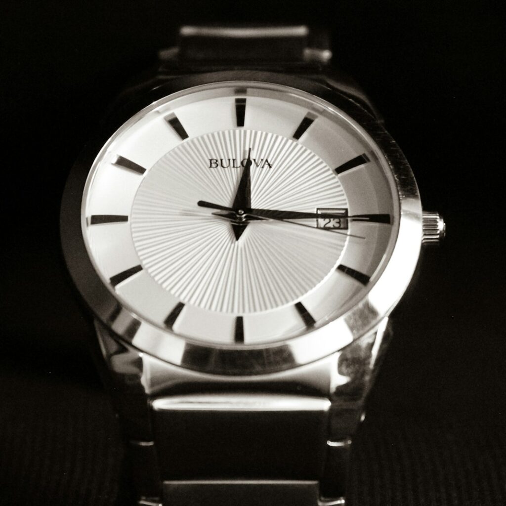 a silver watch with a black band