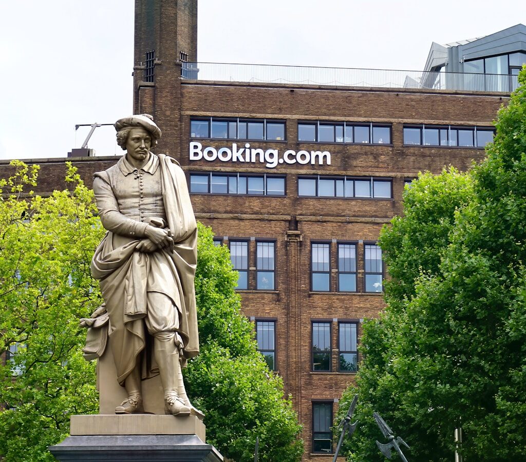 statue of man holding book near brown concrete building during daytime