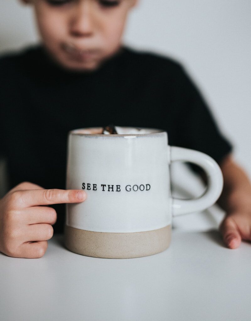 man in black long sleeve shirt holding white ceramic mug