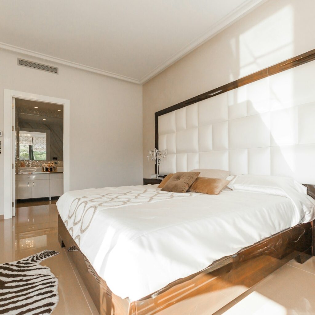 brown wooden bed frame with white cover beside brown wooden nightstand