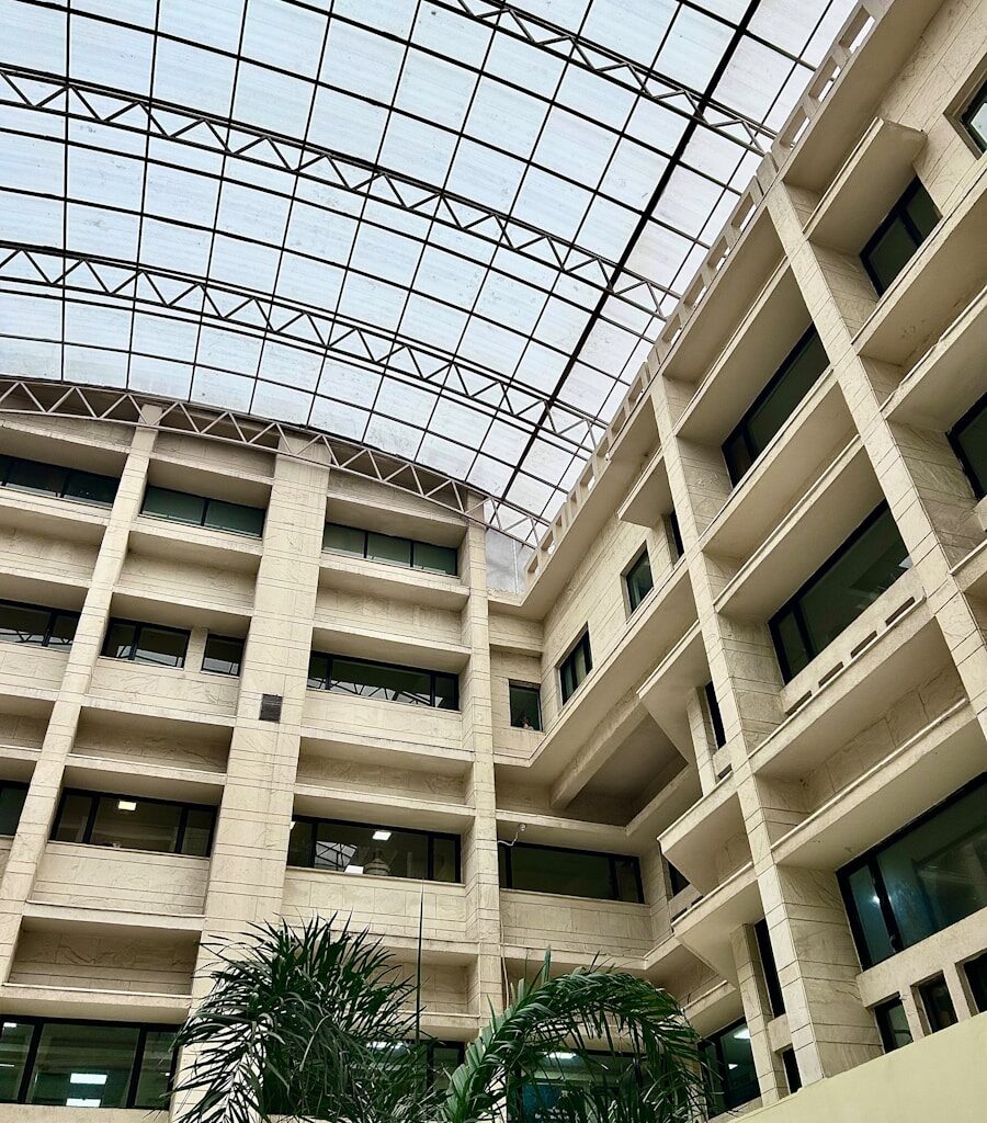 a large building with a glass roof and palm trees