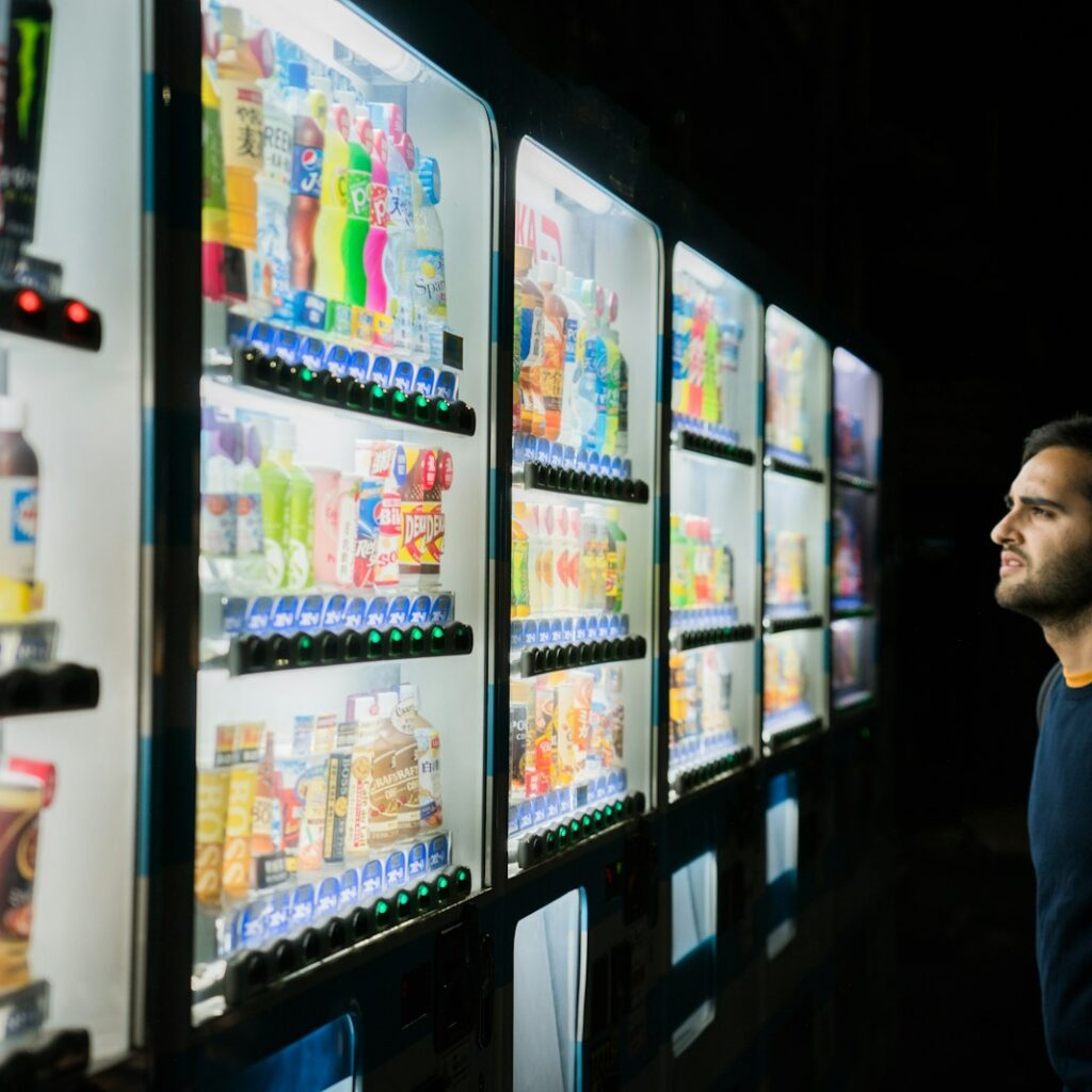 man on front of vending machines at nighttime