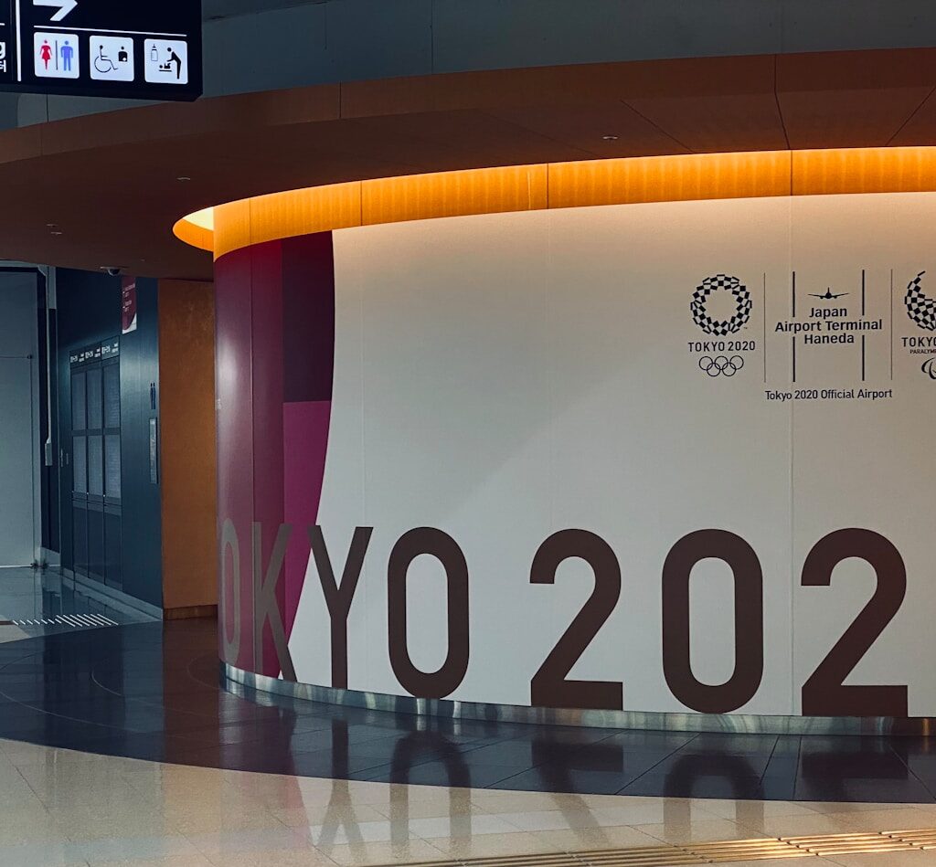 a man standing in front of a large sign in an airport