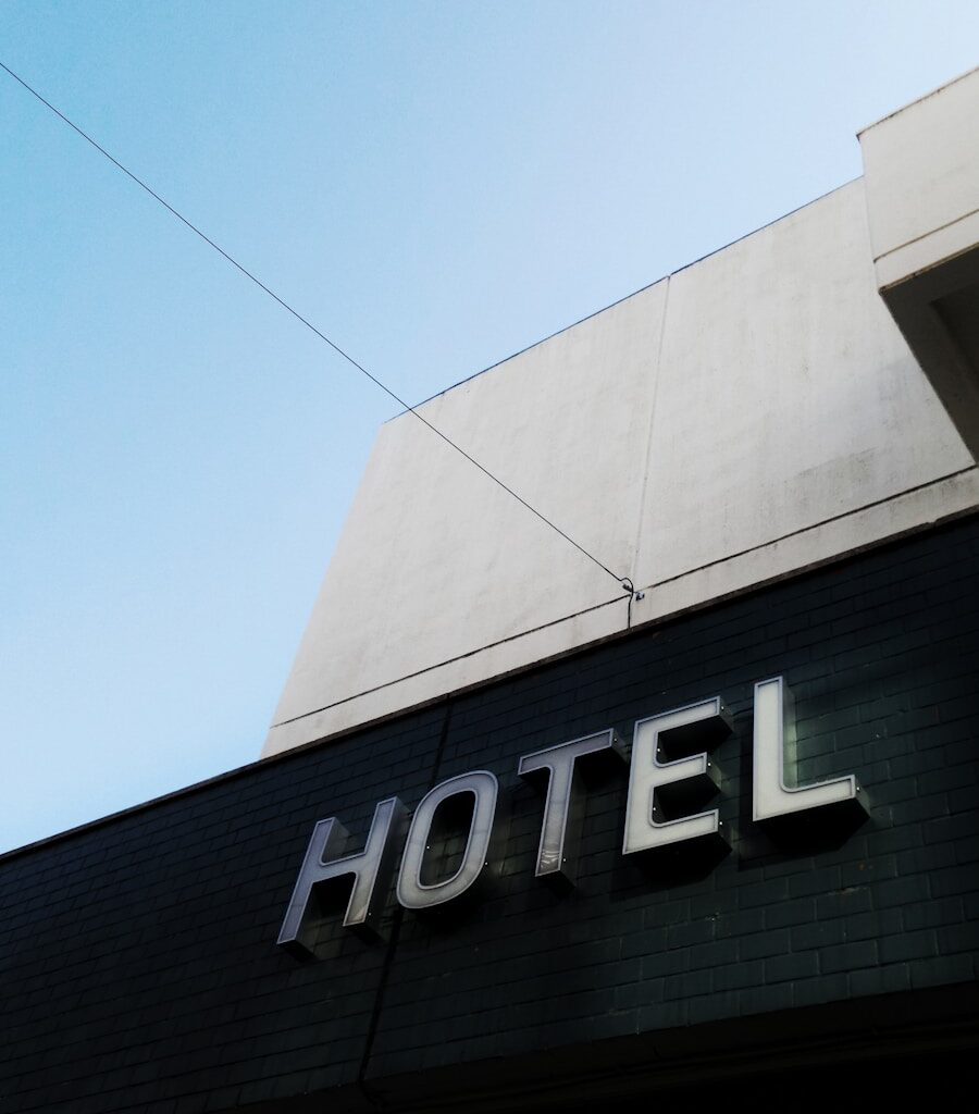 black and white concrete hotel building under a calm blue sky