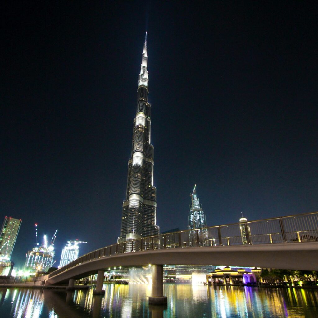 skyline photography of bridge near high-rise buildings at nighttime