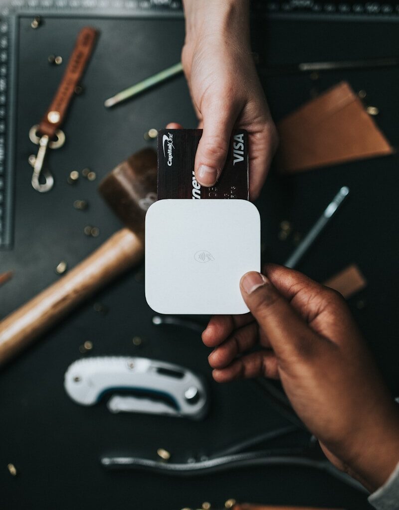 person holding Visa card and white device