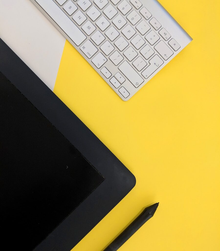 gray Apple wireless keyboard beside black tablet computer and stylus pen