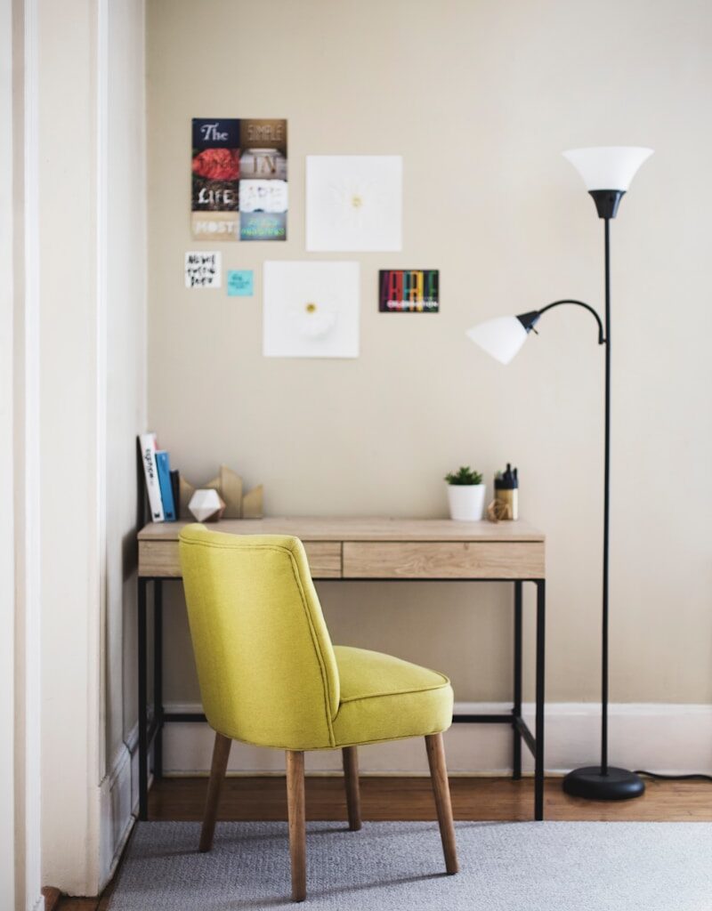 black 2-light torchiere beside brown wooden-top desk with black steel frame