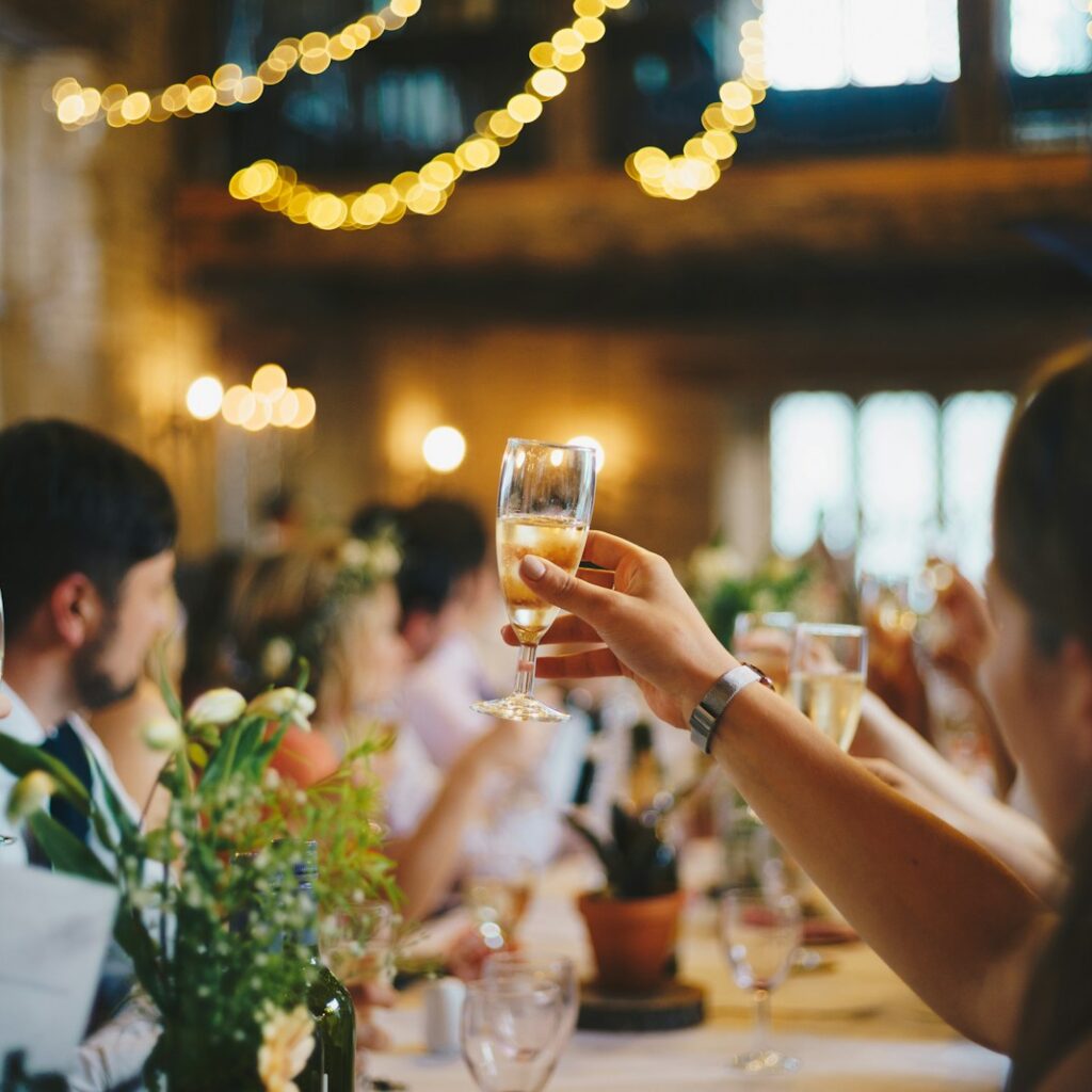 people raising wine glass in selective focus photography