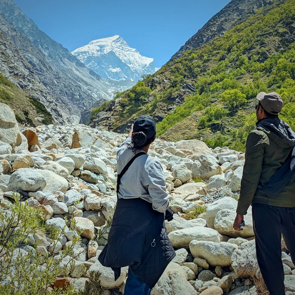 a group of people walking on a rocky path in the mountains