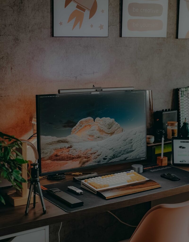 a desk with a computer and a laptop on it