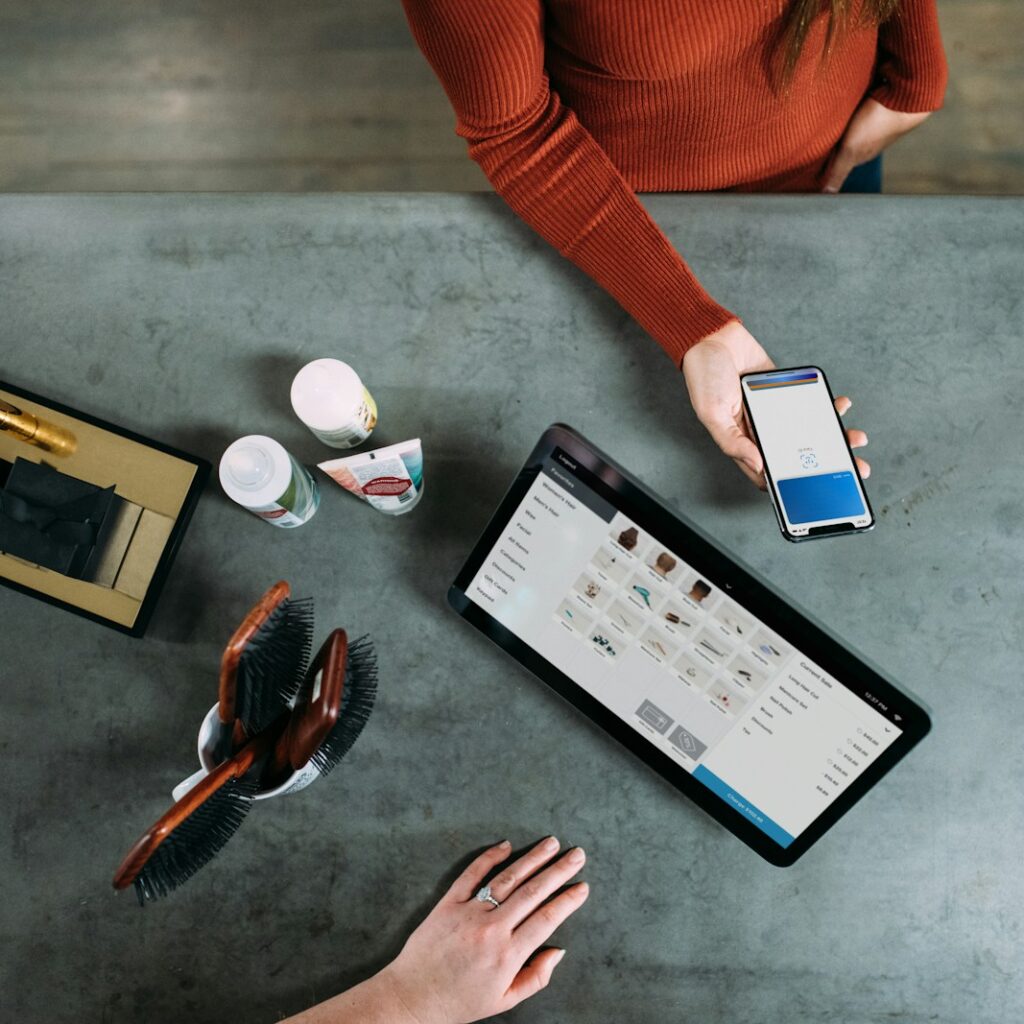 person holding smartphone beside tablet computer