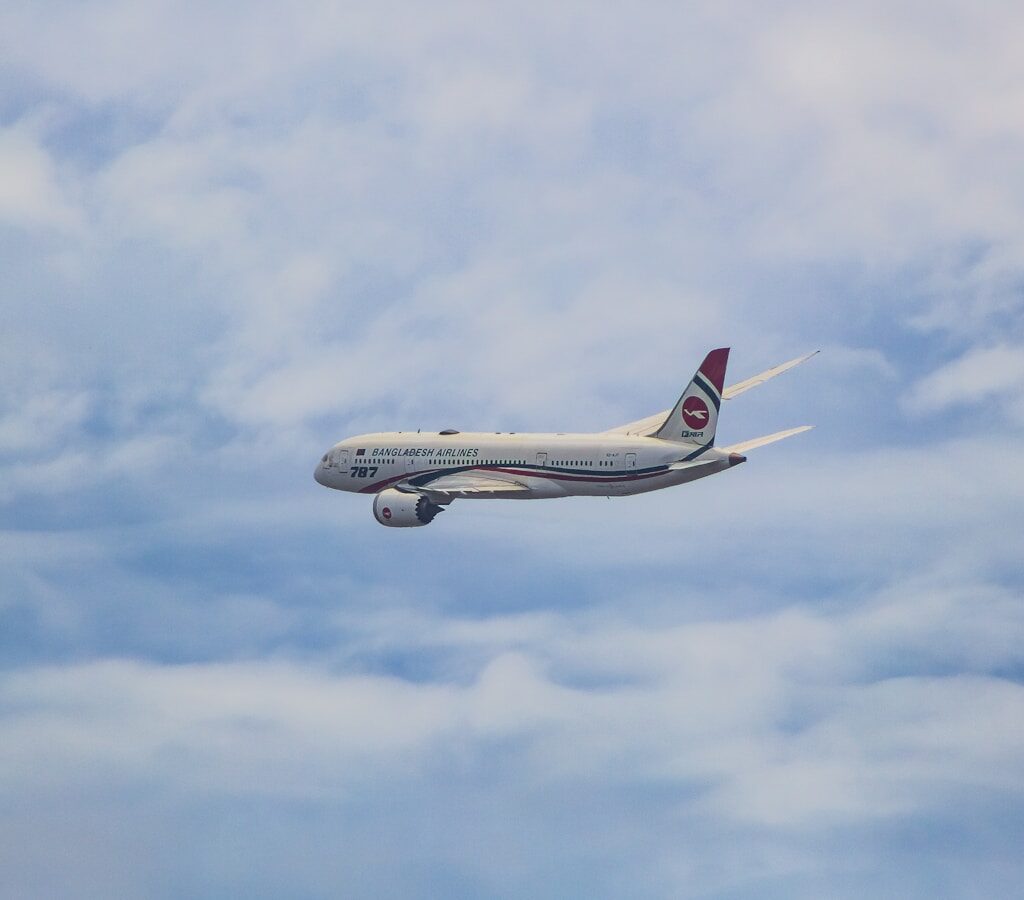 a large jetliner flying through a cloudy blue sky