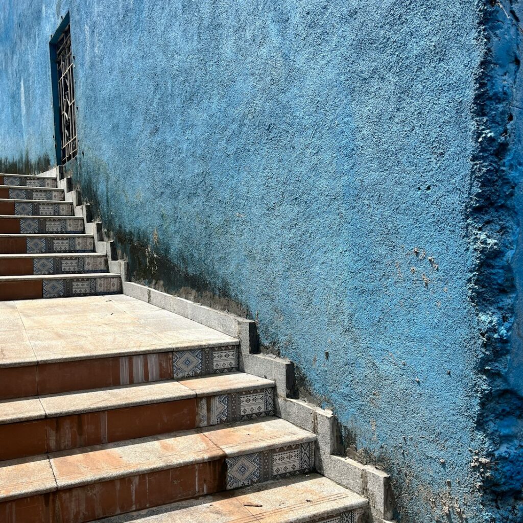 a set of steps leading up to a blue wall